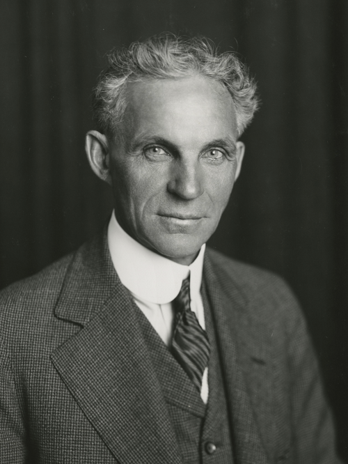Black and white portrait of a man in formal attire against a dark background. Henry Ford portrait 1915