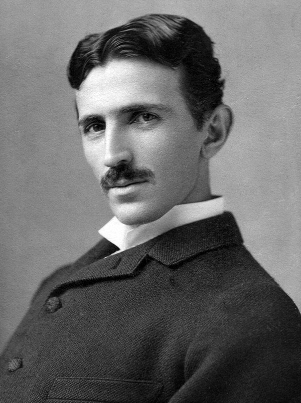 Black and white portrait of a man with a mustache against a plain background